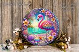 A decorative plate featuring a vibrant pink flamingo surrounded by tropical flowers, seashells, and a starfish, with the word "Hello" written on it. The plate is placed on a wooden surface, and there is a small bird figurine nearby.
