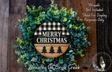 A wreath made of green foliage and a wooden sign with the text "MERRY CHRISTMAS" in the center, surrounded by a wooden background.