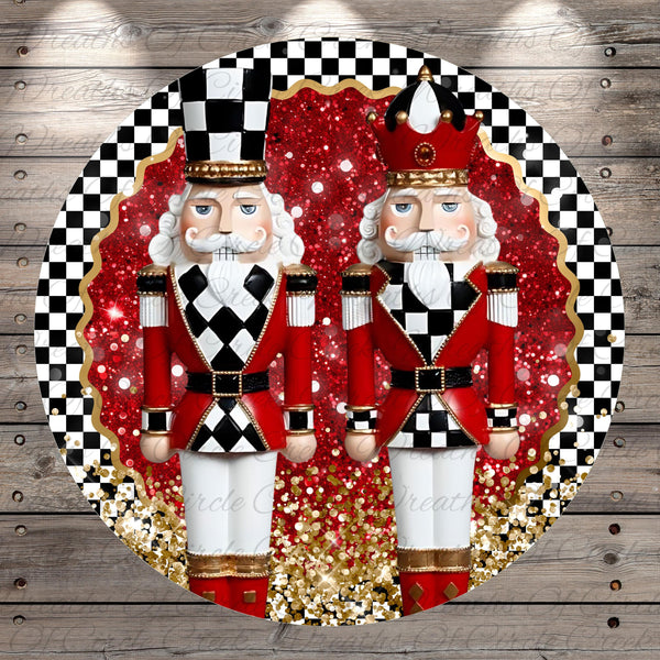 A circular arrangement of two nutcracker figurines, one wearing a red and white outfit and the other in a red and white outfit with a black and white hat, set against a background of red and gold glitter and a black and white checkered pattern.