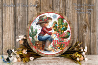 A decorative round plaque featuring a woman in a cowboy hat sitting next to a cactus, surrounded by flowers and holiday decorations.