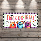 a trick or treat sign hanging on a wooden wall