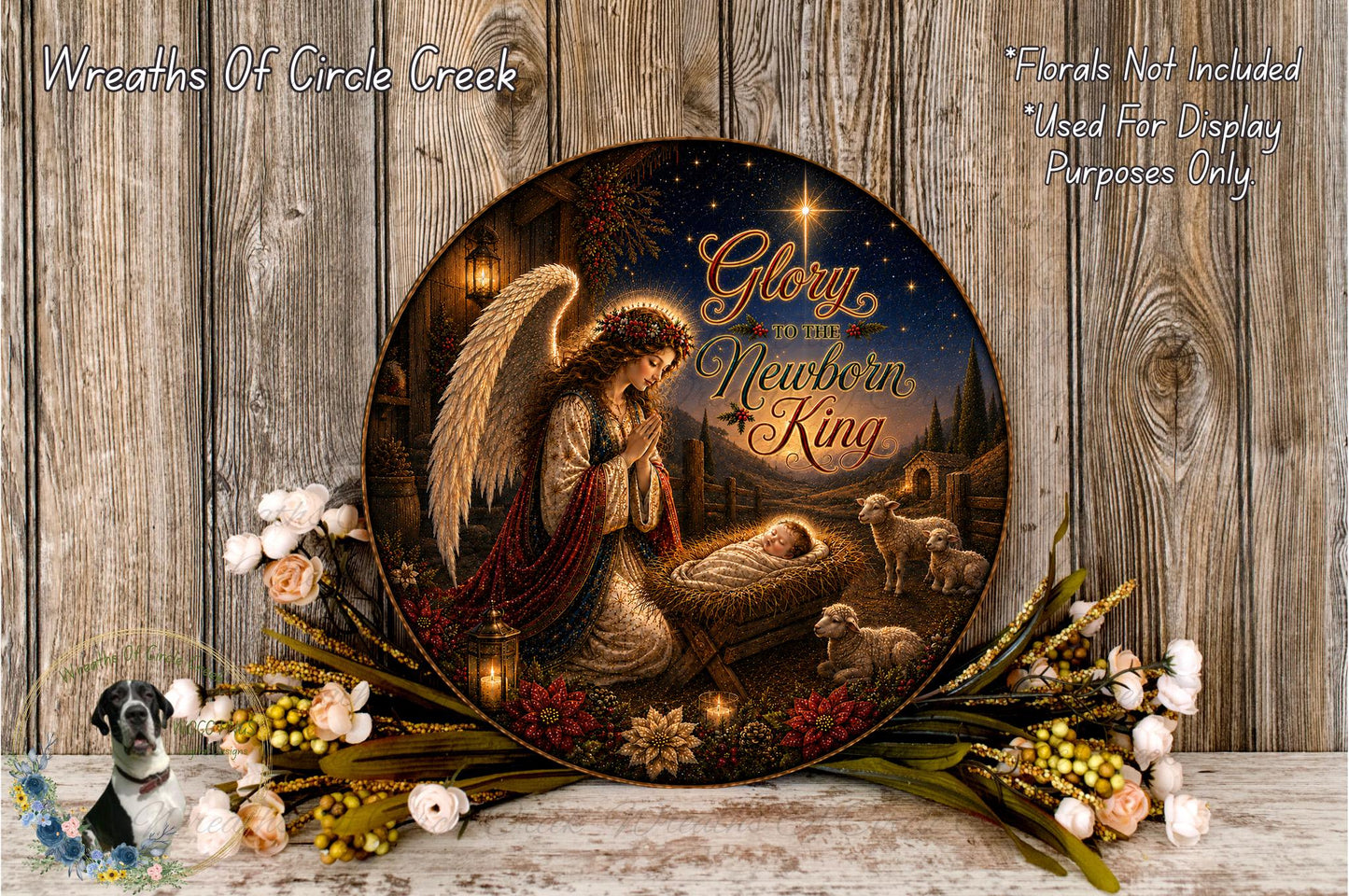 A decorative plate featuring an angelic figure, a baby in a manger, and various floral elements arranged on a wooden surface.
