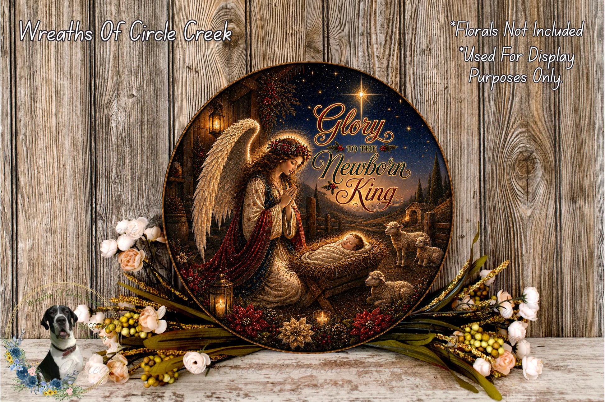 A decorative plate featuring an angelic figure, a baby in a manger, and various floral elements arranged on a wooden surface.