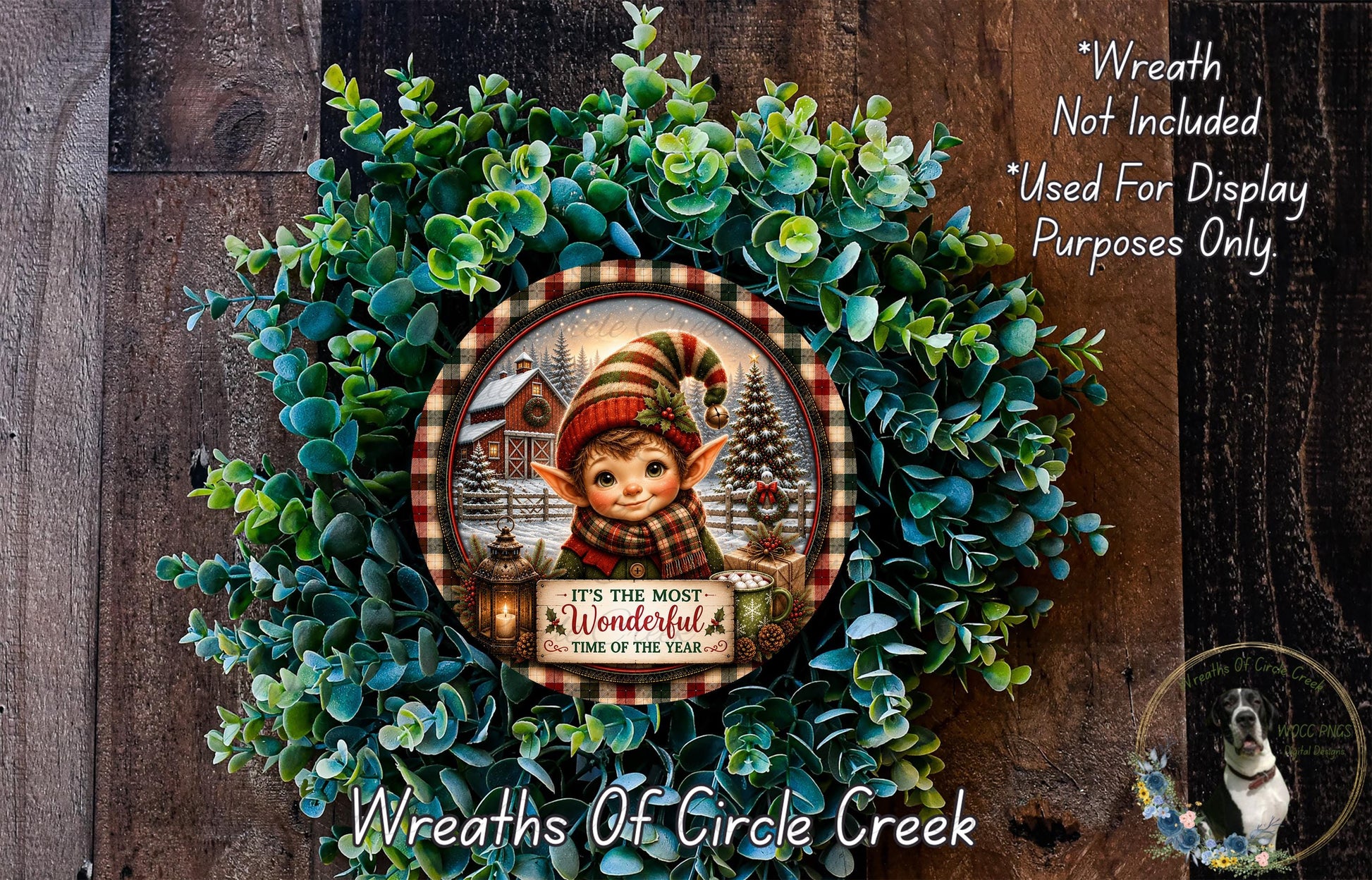 A wreath made of green foliage, featuring a small elf wearing a red and white striped hat and scarf, with a sign that says "It's the most wonderful time of the year".