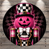 A whimsical illustration of a jack-o-lantern wearing a top hat and a black and white checkered suit, with a bow tie and a pink pumpkin face.