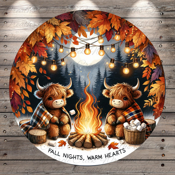 A cozy scene of two furry animals, possibly bison or cows, sitting around a campfire and enjoying the warmth and comfort of the fire. The background features a forest with autumn leaves, and string lights are strung up around the scene, creating a festive atmosphere. The text "FALL NIGHTS, WARM HEARTS" is displayed, suggesting a seasonal theme related to the fall season.