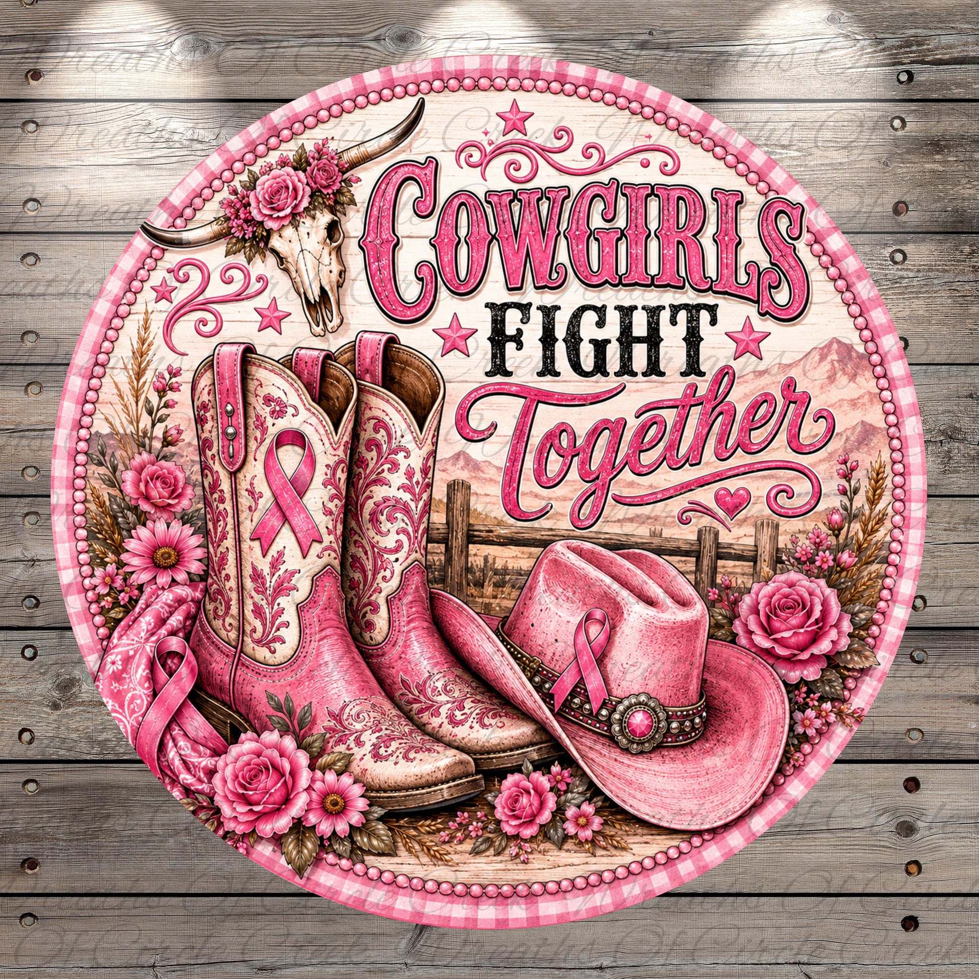 a round, decorative sign with a pink and white color scheme. The sign is adorned with various elements, including cowboy boots, a hat, and flowers. The text on the sign reads "COWGIRLS FIGHT TOGETHER".