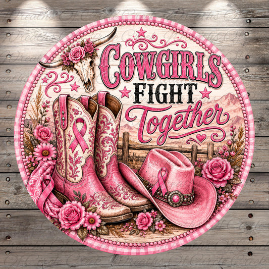 a round, decorative sign with a pink and white color scheme. The sign is adorned with various elements, including cowboy boots, a hat, and flowers. The text on the sign reads "COWGIRLS FIGHT TOGETHER".