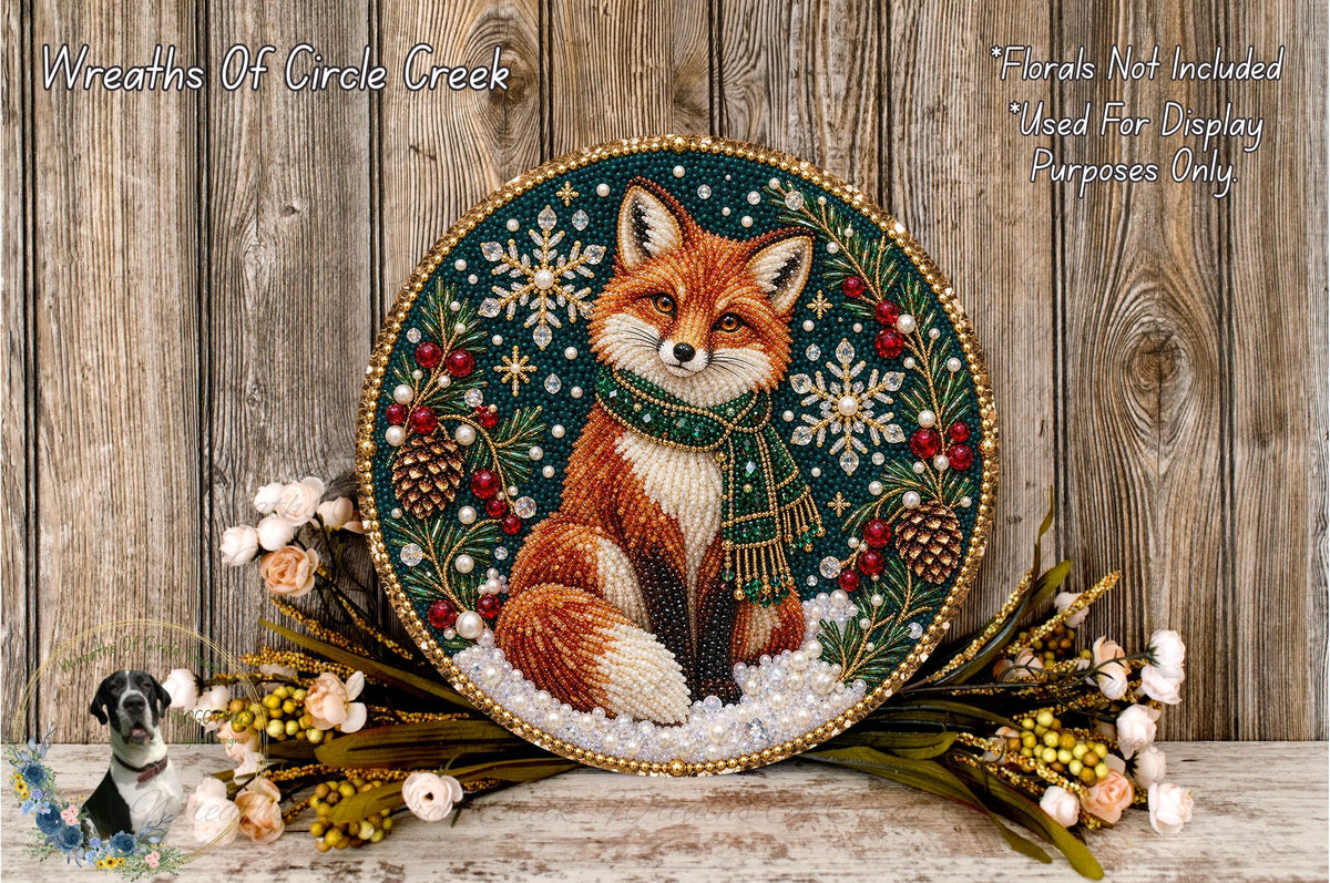 A decorative wreath featuring a fox surrounded by snowflakes, pine cones, and flowers, placed on a wooden surface.
