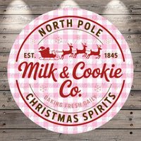 a circular logo for a company called "Milk & Cookie Co." with a Santa Claus sleigh and reindeer design. The logo is set against a pink and white checkered background.