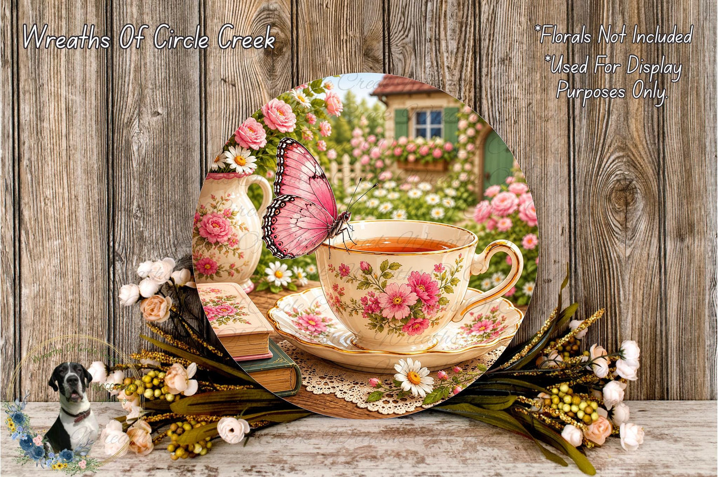 A floral arrangement with a teacup and saucer, a butterfly, and a vase of flowers, set against a wooden background.