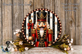 A nutcracker figure surrounded by a decorative wreath and flowers, with a wooden background.