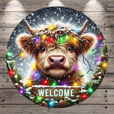 A close-up of a cow&#39;s face with a wreath of colorful lights around its horns, set against a snowy background with falling snowflakes. The word &quot;WELCOME&quot; is displayed in the center of the image.