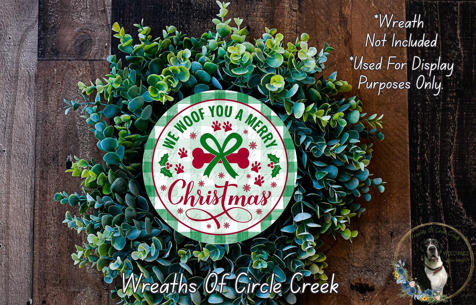 A Christmas wreath made of green and red evergreen branches, with a circular sign in the center that says "We Wrote You A Merry Christmas".