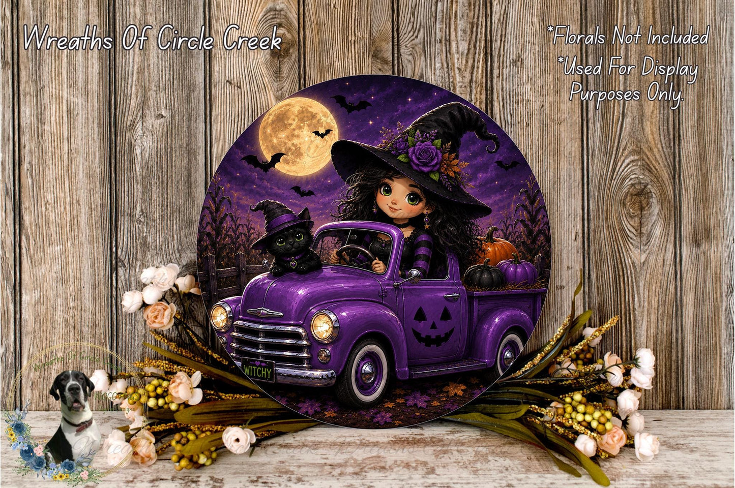 A Halloween-themed wreath featuring a purple truck with a witch and a black cat, surrounded by flowers and a full moon.