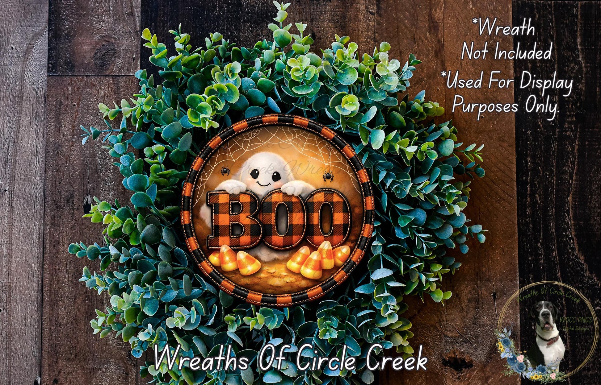A Halloween-themed wreath made of green foliage and orange and black checkered trim, with a ghost and the word "BOO" prominently displayed.