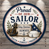 The image is a circular sign with a patriotic design featuring an anchor, a sailor hat, and the text "Proud of our Sailor" along with the phrases "Today, Tomorrow, Always" and "Faith * Family * Freedom".