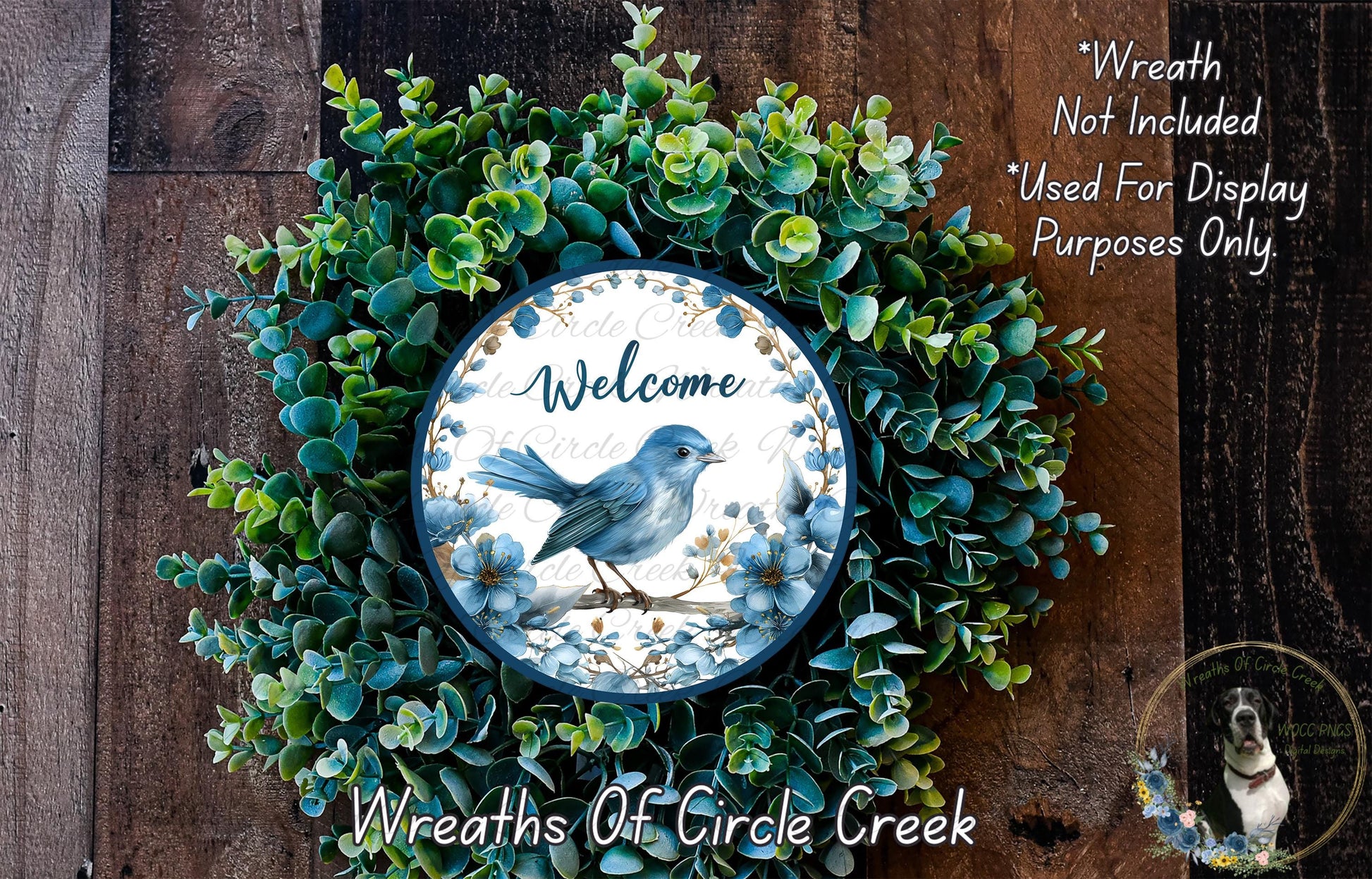 a wreath with a blue bird on a branch, surrounded by green foliage. The wreath is displayed on a wooden surface, and there is a text overlay that reads "Welcome Wreath Not Included * Used For Display Purposes Only" and "Wreaths Of Circle Creek".