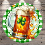 A mug of beer with a shamrock on it, surrounded by bubbles and foam, against a green and white checkered background.