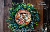 a wreath with a cow and a pig inside, surrounded by a lush green plant. The wreath is displayed on a wooden surface, and there is a small dog in the bottom right corner of the image.