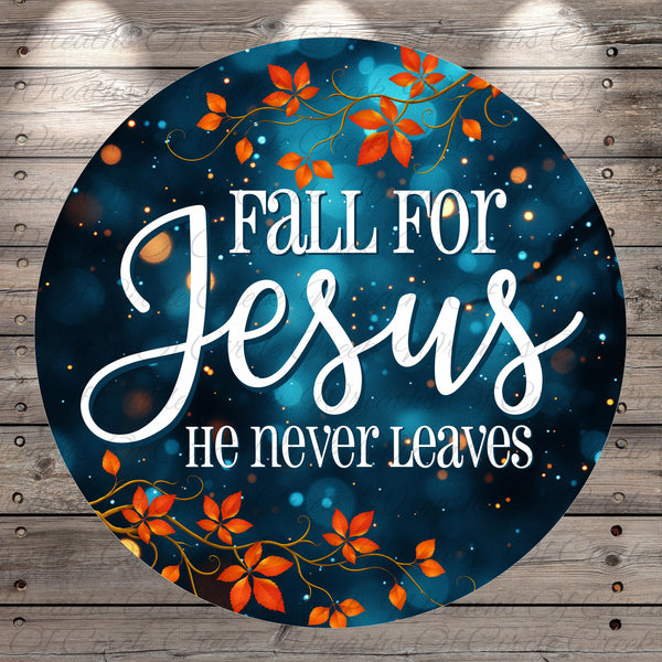 The image is a circular graphic with a blue background and orange leaves. The text "Fall for Jesus" is written in white cursive font, and below it, "He never leaves" is written in white block font.