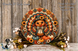 A decorative wreath featuring a colorful turkey surrounded by autumn foliage, flowers, and pumpkins, placed on a wooden surface.