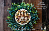 A Christmas wreath made of green foliage and adorned with three gnomes, with a sign that says "Merry Christmas". The wreath is displayed on a wooden surface, and there is a text overlay that reads "Wreath Not Included * Used For Display Purposes Only".