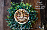 A Christmas wreath made of green foliage and adorned with three gnomes, with a sign that says "Merry Christmas". The wreath is displayed on a wooden surface, and there is a text overlay that reads "Wreath Not Included * Used For Display Purposes Only".