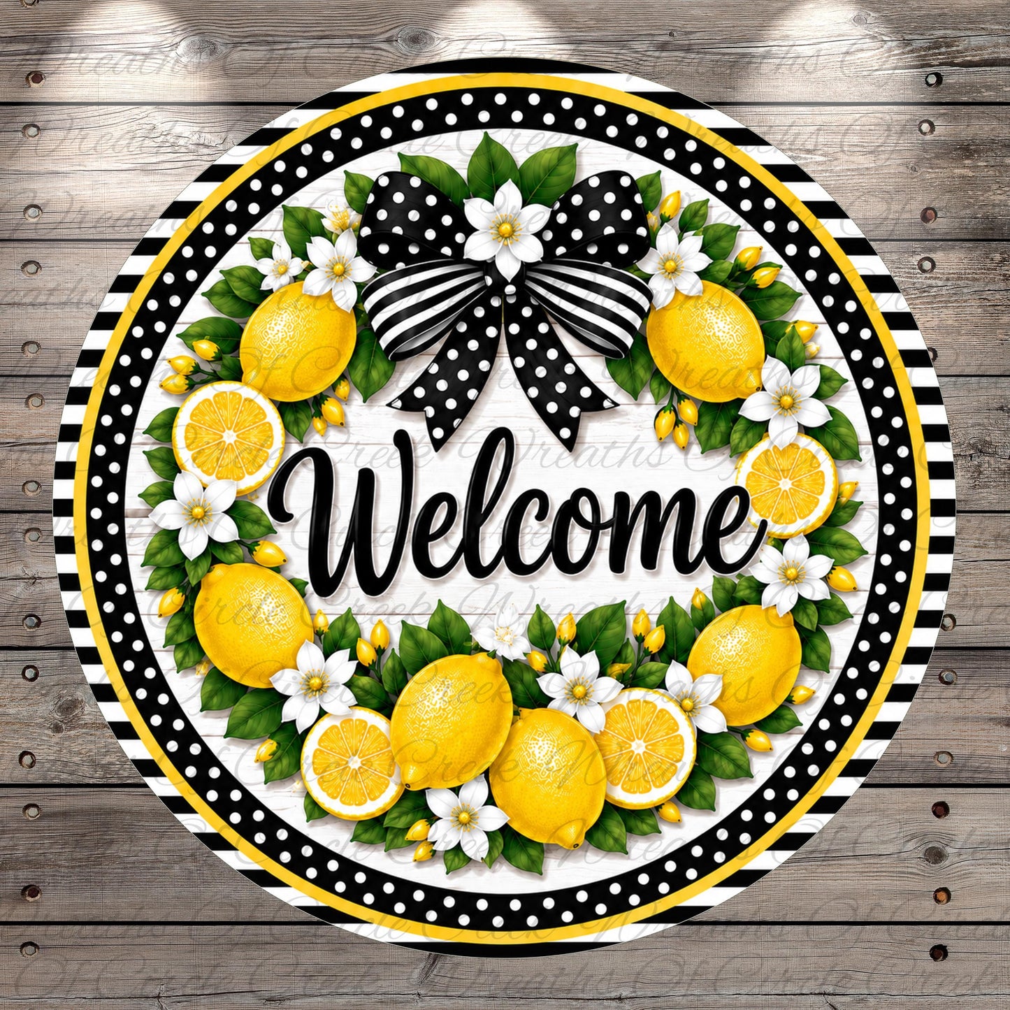 A decorative wreath with a black and white polka dot border, surrounded by yellow lemons, white flowers, and green leaves. The word "Welcome" is written in cursive on the wreath.