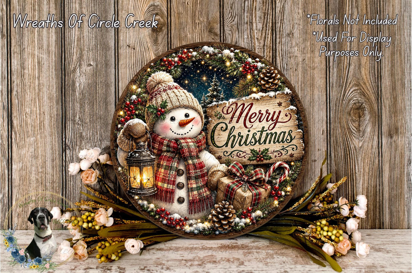 A festive wreath with a snowman, lantern, and Christmas-themed decorations, including pine cones, berries, and flowers, set against a rustic wooden background.