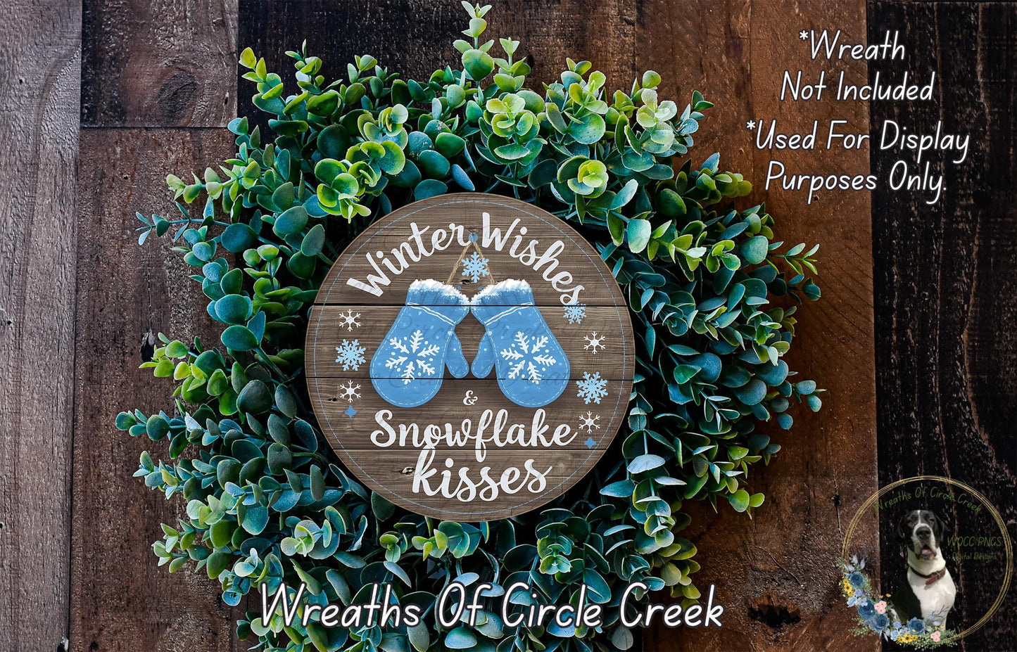 A wreath made of green leaves and snowflakes, with a wooden sign that says "Winter Wishes & Snowflake Kisses" in the center.