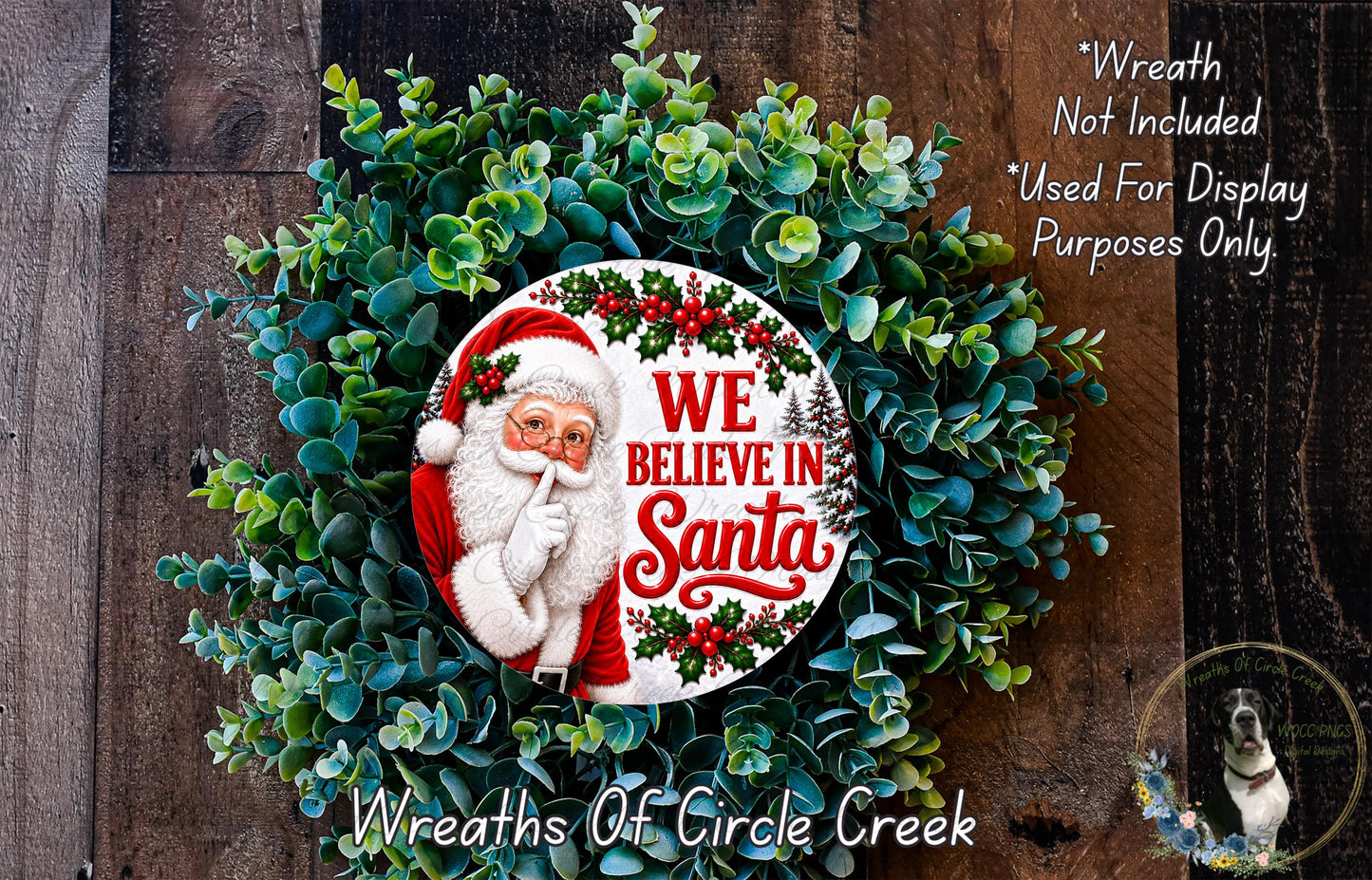 A wreath made of green foliage and featuring a Santa Claus image, with the text "We Believe in Santa" displayed on it.