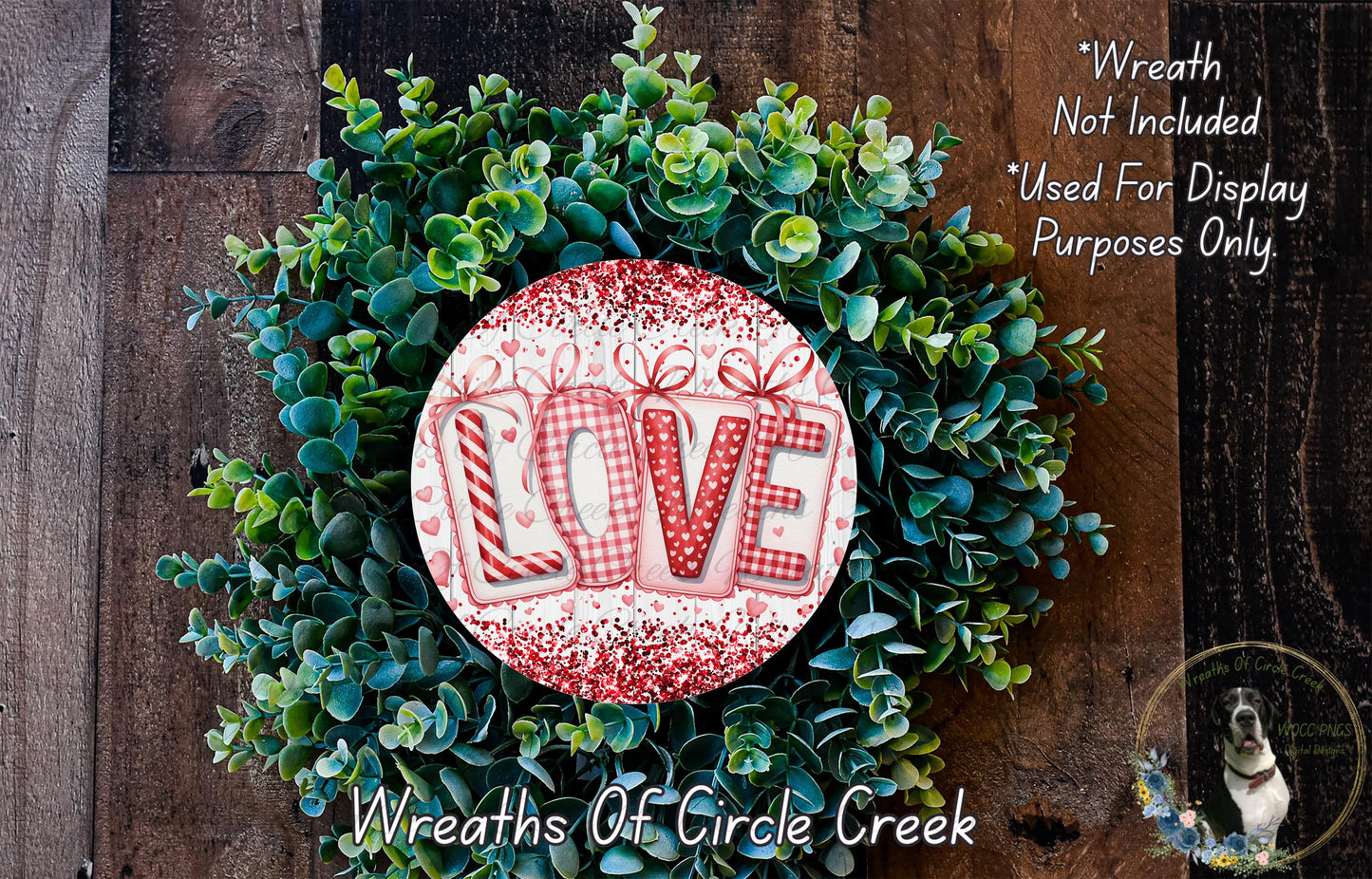 A wreath made of green leaves and a red and white circular sign with the word "LOVE" written on it.