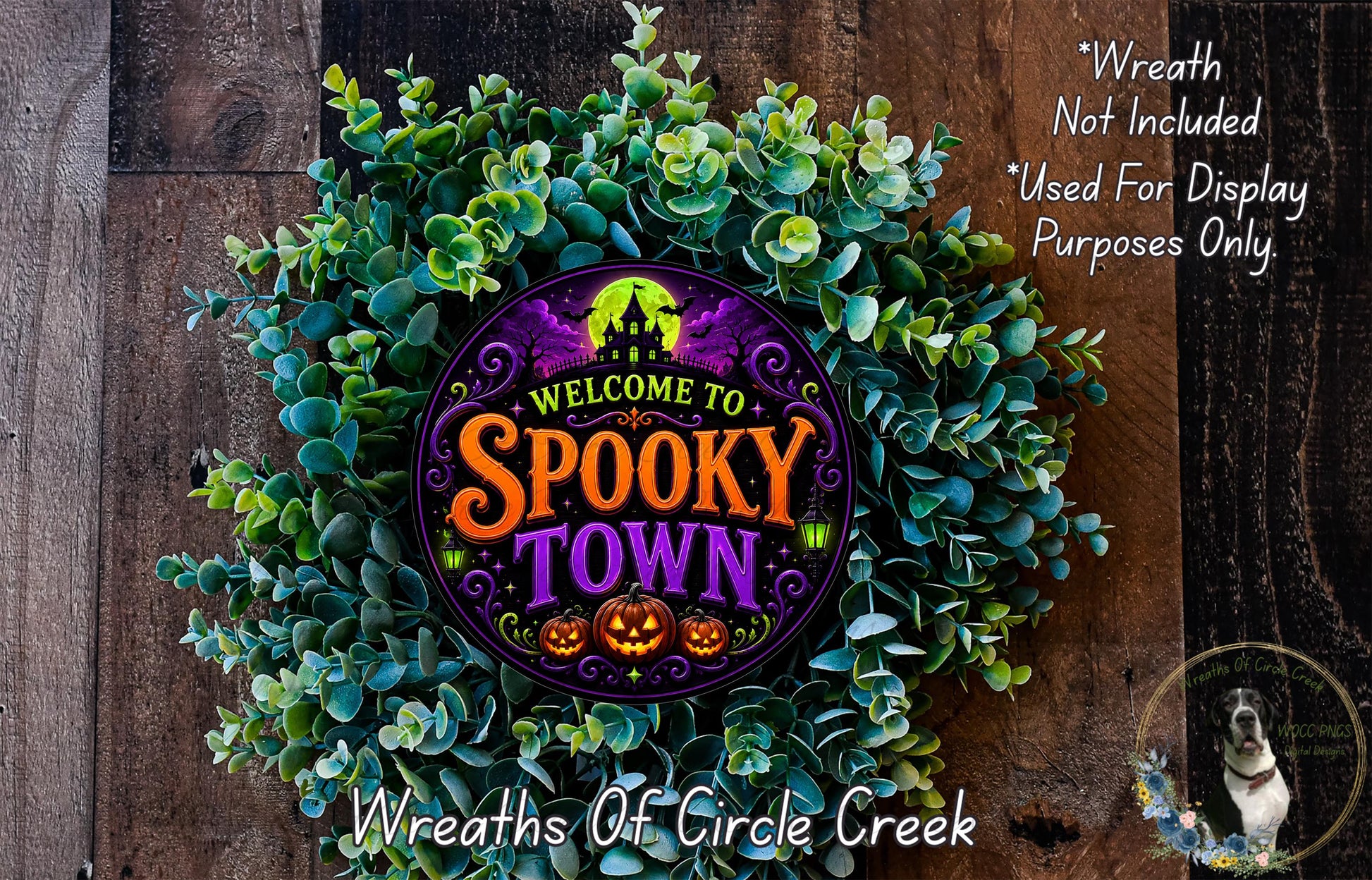 a wreath with the text "Welcome to Spooky Town" and a spooky house silhouette, surrounded by green foliage.
