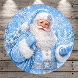 A round, blue-colored illustration of Santa Claus wearing a blue suit and hat, holding a bag of presents, with snowflakes falling around him.