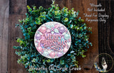 A wreath made of green leaves and colorful ornaments, with the text "Merry Christmas" displayed on it.