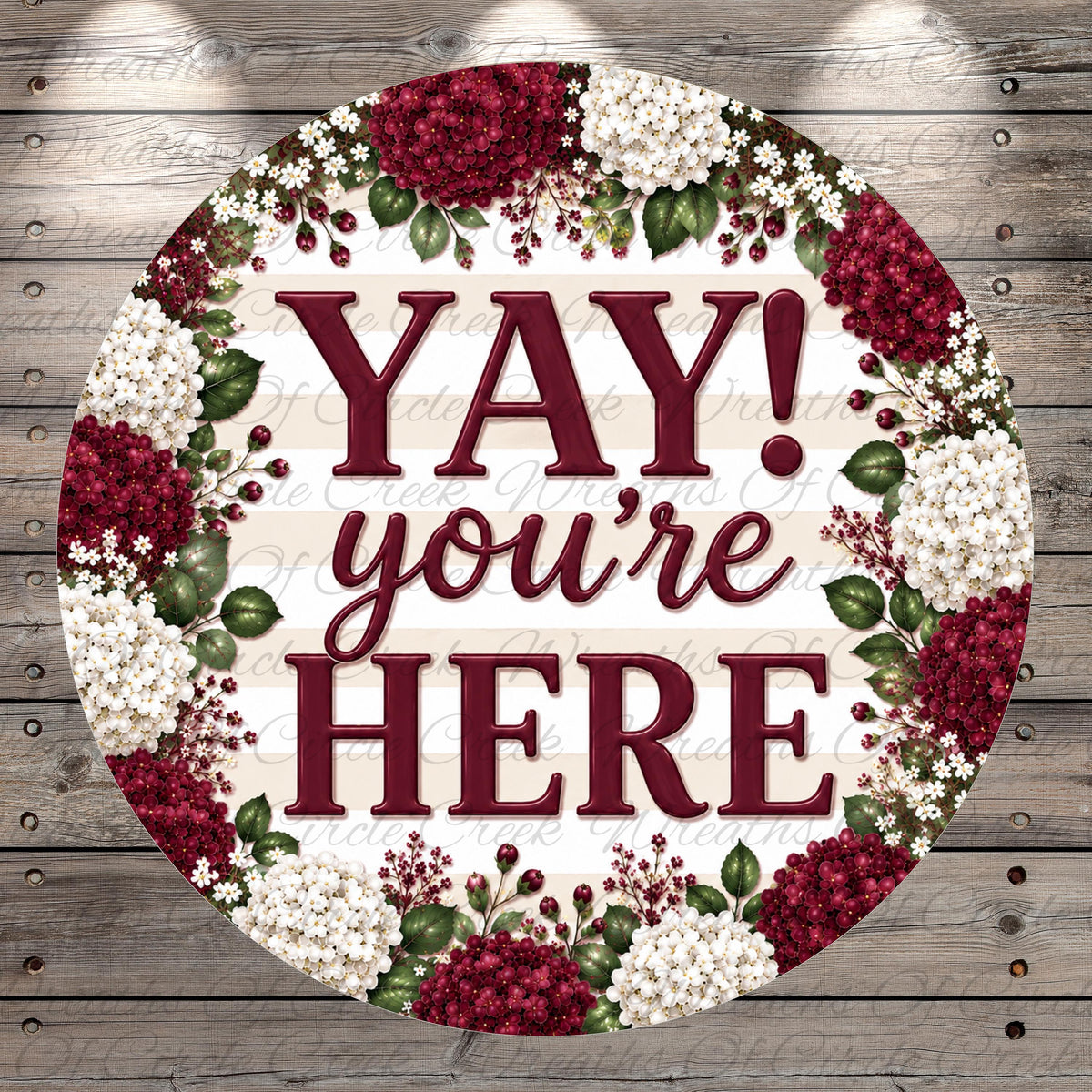 A circular sign with the text "YAY! you're here" surrounded by a floral border of red and white flowers.
