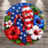 A vibrant and patriotic design featuring a pair of red flip-flops surrounded by flowers and leaves, including hibiscus blooms, against a backdrop of the American flag.