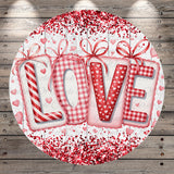 A circular design featuring the word "LOVE" in a decorative font, surrounded by red and white polka dots and ribbons.