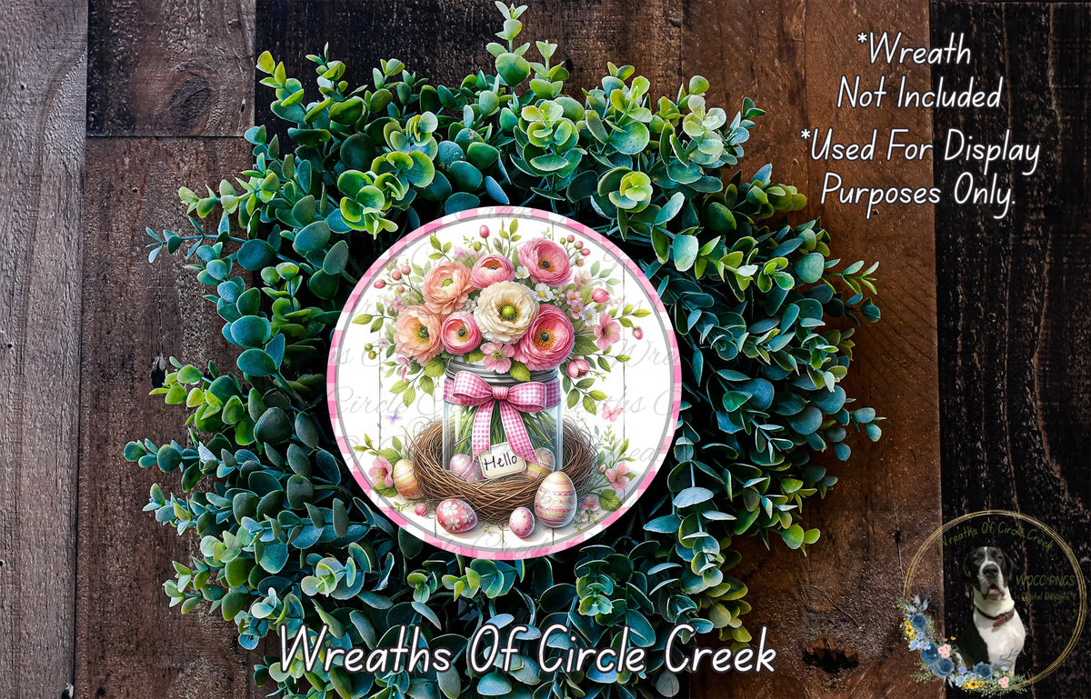 a wreath with a floral arrangement and a sign that says "Hello" in the center. The wreath is made of green leaves and flowers, and there is a small sign with the word "Hello" on it. The background is a wooden wall with some text and a small image of a dog.