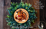 A wreath made of green foliage and featuring a cartoon turkey wearing a hat, with the text "Wreath Not Included * Used For Display Purposes Only" and "Wreaths Of Circle Creek" written above it.