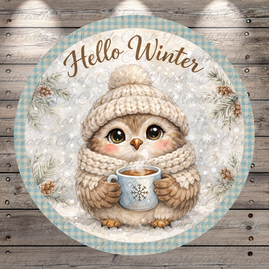 A cozy illustration of a small owl wearing a winter hat and scarf, holding a mug of hot chocolate, with the text "Hello Winter" written above it.