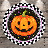 A cheerful jack-o-lantern with a smiling face is surrounded by a checkered border and colorful dots against a black background.