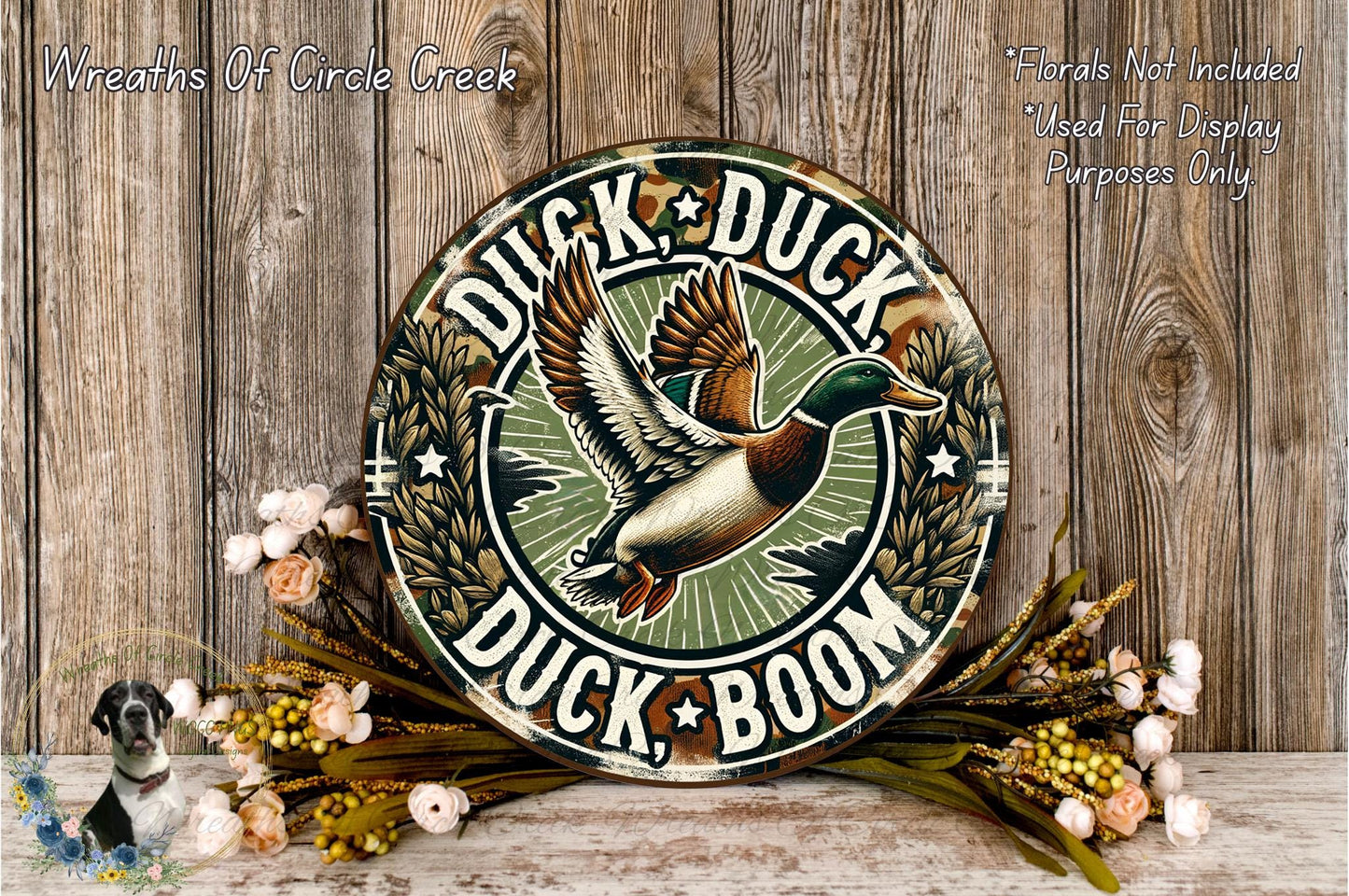 A decorative sign featuring a duck in mid-flight, surrounded by flowers and foliage, with the text "Duck, Duck, Boom" prominently displayed.