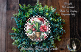 A wreath made of various green plants, including cacti and pine cones, with a red and white checkered border. The wreath is displayed on a wooden surface, and there is a small dog in the bottom right corner.
