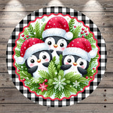 A festive Christmas-themed image featuring three cheerful penguins wearing Santa hats, surrounded by a wreath of greenery and berries, all set against a checkered background.