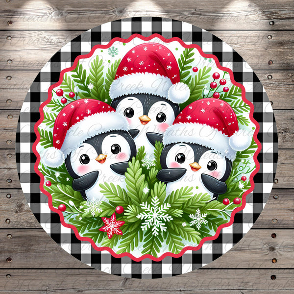 A festive Christmas-themed image featuring three cheerful penguins wearing Santa hats, surrounded by a wreath of greenery and berries, all set against a checkered background.