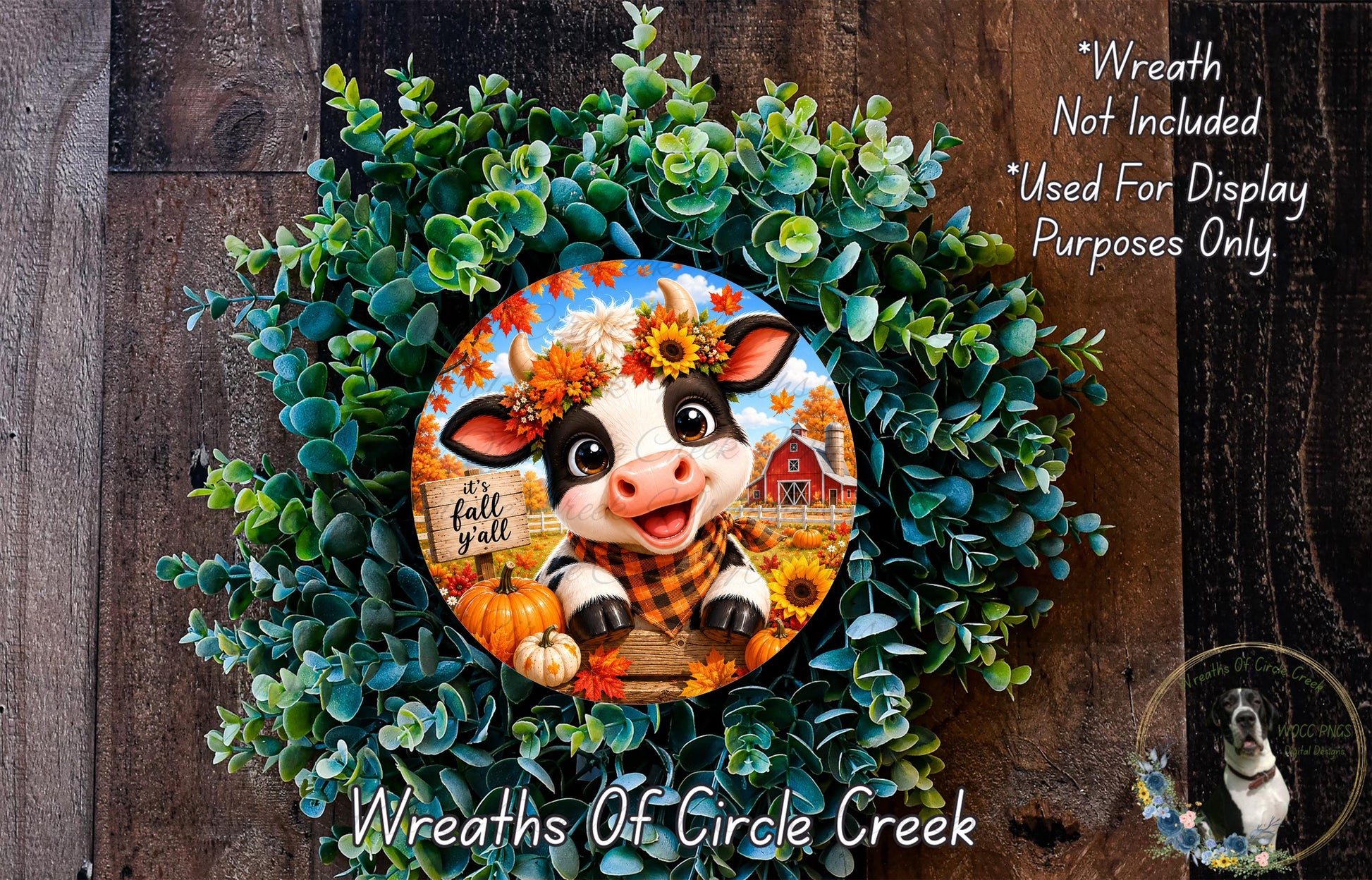 a wreath with a cow and fall-themed decorations, including pumpkins and sunflowers, set against a wooden background.