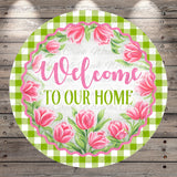 A round sign with a floral border and the text "Welcome to our home" in pink cursive font.