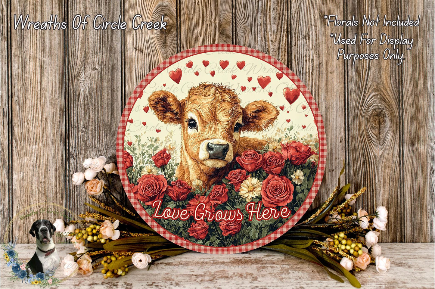 a round wooden plaque with a cow's face surrounded by red roses and greenery, along with the text "Love Grows Here".